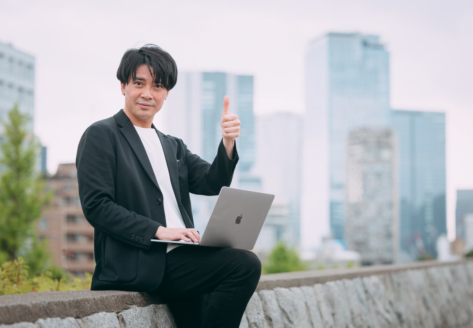 ノートパソコンで開発作業をしながら満足げに確認するエンジニア