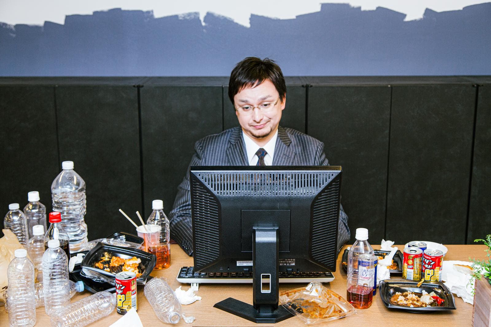 仕事終わりにデスクで転職活動の情報を確認するビジネスパーソン