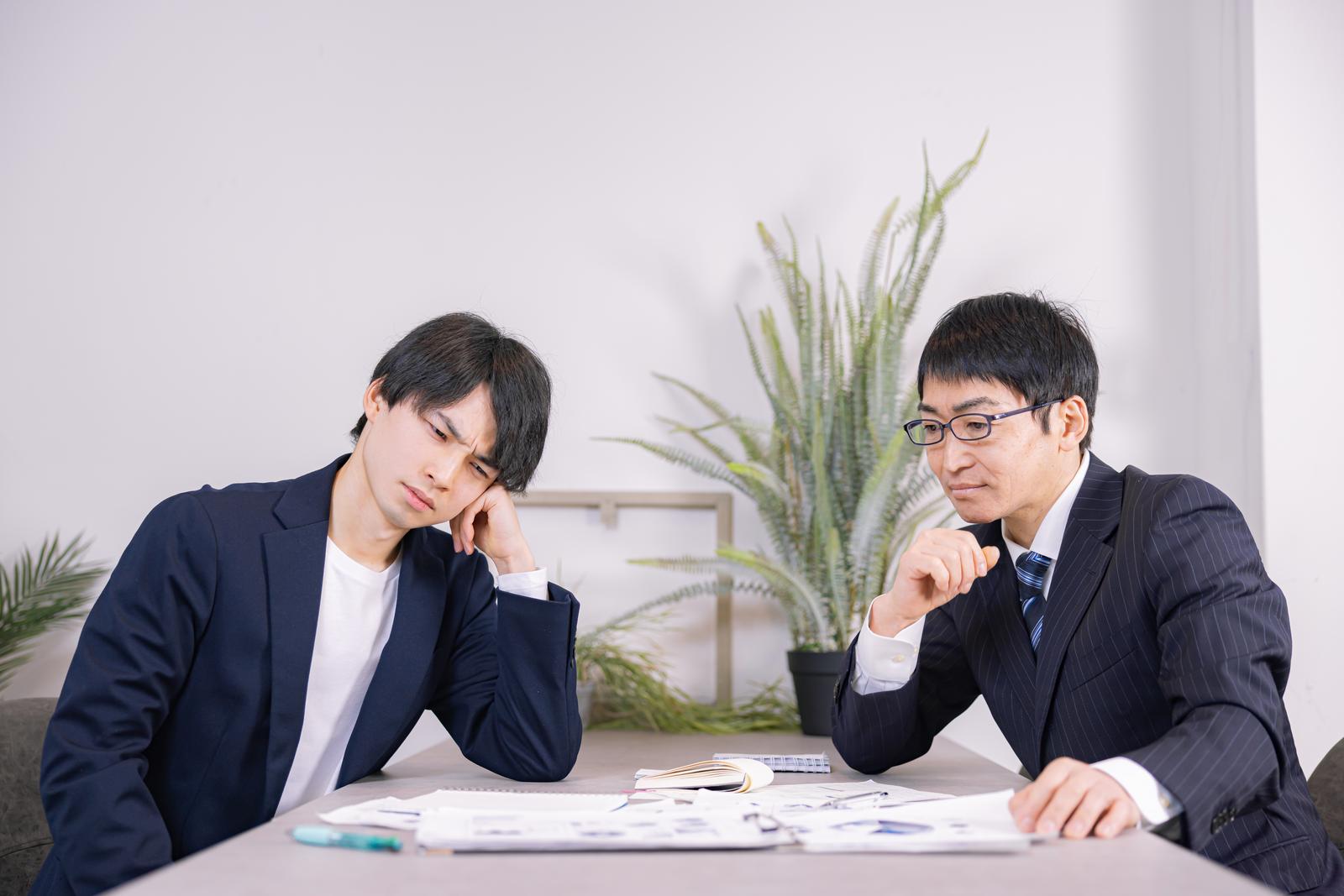 資料を見ながら転職サービスの違いを比較するビジネスミーティング